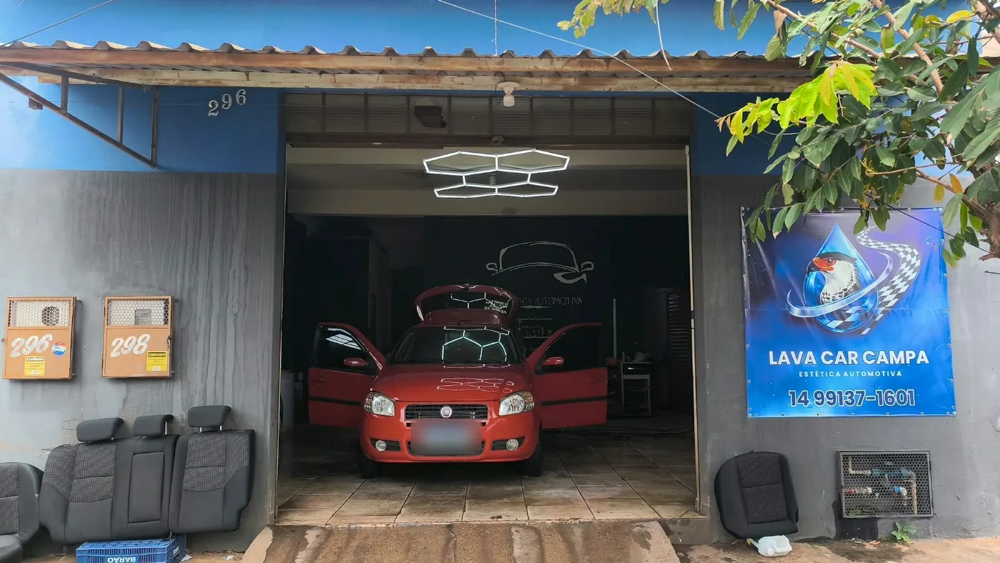 Fachada da Lava Car Campa, número 296, com o banner da loja e um carro sendo atendido